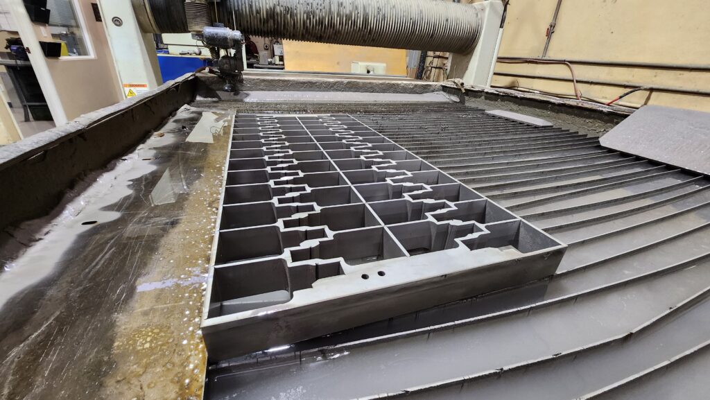 Waterjet machine cutting intricate metal parts in San Diego, CA